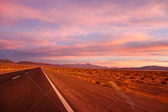 Purple colored magical sunset. desert road in a mountainous region