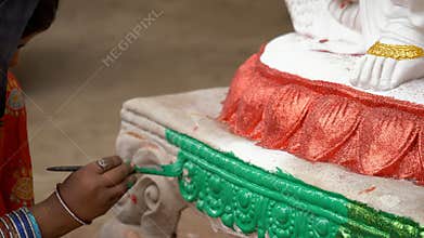 â€‹Woman clay craftsperson painting the designs of an idol of an Indian Goddess