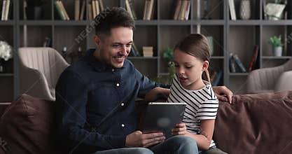 Happy bonding young father and small kid using tablet.