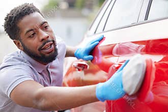 Man Polishing Bodywork Of Car During Valet