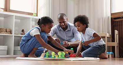 Loving African dad play wooden constructor with son and daughter