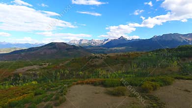 Aerial over field towards majestic Colorado Rocky Mountains range