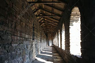 Old stone gallery with arched windows on the castle wall.