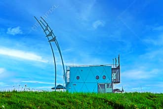 A small building on an embankment overlooking the sea.