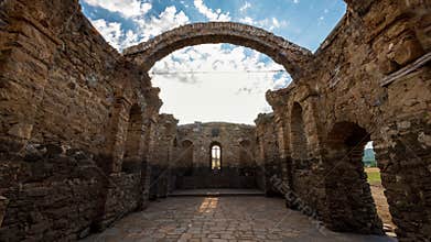 Time lapse with moving clouds between the ruins of an old church