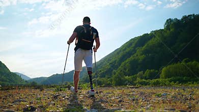 young man with prosthetic leg is travelling alone in nature in summer
