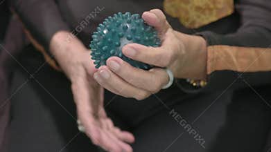 Elderly woman doing rubber ball for exercise fingers, palm and hand  muscle