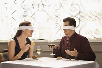 Blindfold couple dining