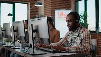 Male employee answering telephone calls on headset