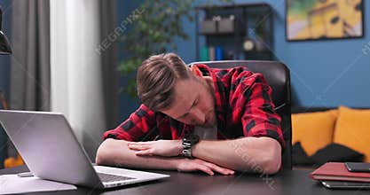 A tired and bored Teenage student boy yawns and falls asleep sitting in a chair