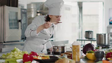 Authentic cook taste testing bad sauce on kitchen stove