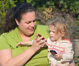 Woman shows cell phone to little girl