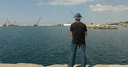 Mid adult man fishing at Aegean sea in Greece