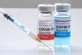 A Moderna 1st dosis and a 2nd dosis of covid-19 vaccine on a vial bottle and injection