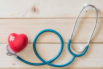 World health day campaign with red love heart  with cross bandage and medical doctor`s stethoscope, first aid concept