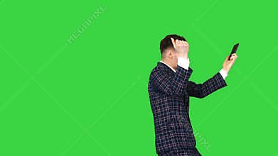 Inspired man in formal receiving good news on the phone and dancing after on a Green Screen, Chroma Key.