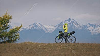 The woman travel on mixed terrain cycle touring with bikepacking. The traveler journey with bicycle bags. Sport tourism