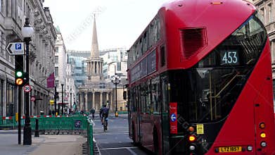 Bicycle riders and red buses in Regent Street London