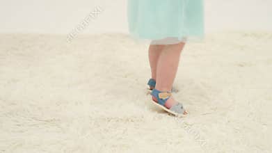 Little girl feet on the white carpet close-up