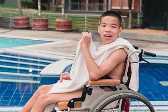 Strong arm muscles of Asian special child on wheelchair with swimming pool