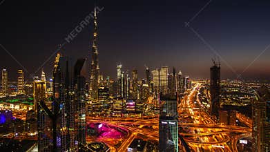 Day to night time lapse of Dubai city center with modern tall skyscrapers and busy street traffic on a highway. Time