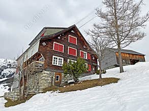 Old traditional swiss rural architecture and alpine livestock farms in the winter ambience of the region over the Lake Walen