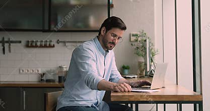 Skilled male worker involved in distant job at home office.