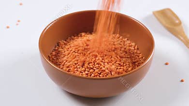 Red lentils in a bowl on white background. Healthy organic food diet concept