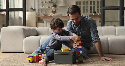 Caring dad play colorful blocks with little son
