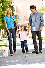 Family walking dog in city street