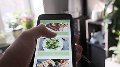 Ordering food from restaurant online using smartphone app close up.