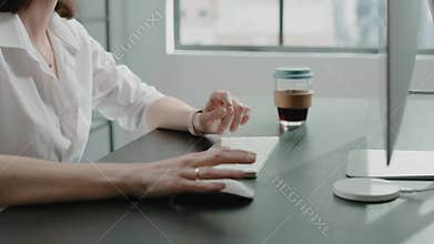 Employee with glasses uses mouse and keyboard of computer