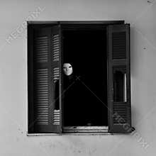 Masked figure by broken window
