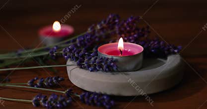 Lavender with scented candles on wooden table