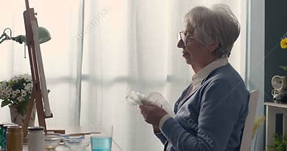 Senior woman looking at her finished artwork