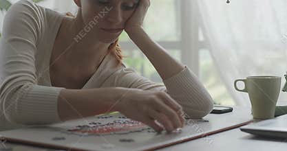 Bored woman composing a puzzle