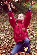 Girl teen playing with autumn leaves up in the air