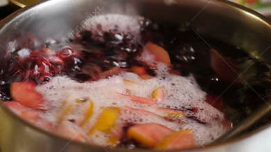 Cooking compot. beverage made of variety fresh berries. Boiling water with berries in saucepan mixing and stirring woth