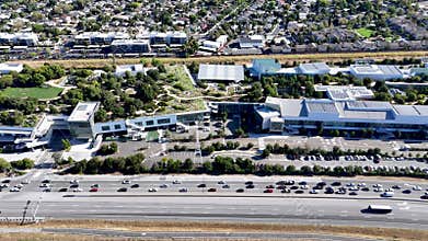 Meta MPK campus aerial view, panning right, with green rooftop gardens, highway, and residential area