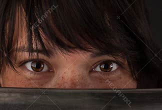 Asian woman looking over the blade of her sword