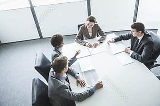 Four business people sitting around a table and having a business meeting, high angle view