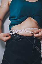 fat woman, fat belly, chubby, obese woman hand holding excessive belly fat with measure tape, woman diet lifestyle concept