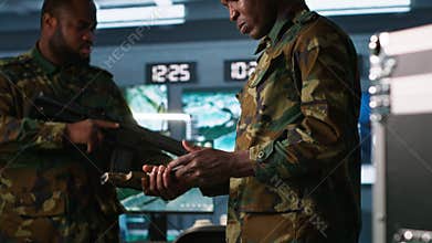 Soldiers doing checkup on rifles and pistols in command post
