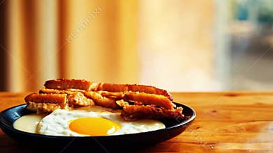 Hot breakfast plate with eggs and toast on wooden table