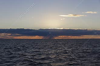 Rain cloud over the water at sunset