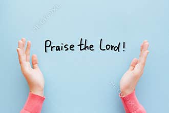 Praise the Lord - Christian lettering on light blue background with praising woman hands