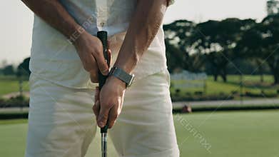 Man takes driver with both hands preparing to hit on course