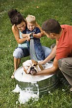 Family giving dog a bath.