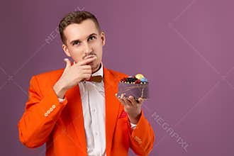 birthday guy holding cake looking at the camera
