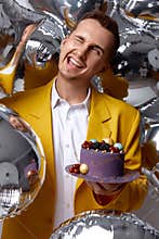 birthday guy holding cake looking at the camera